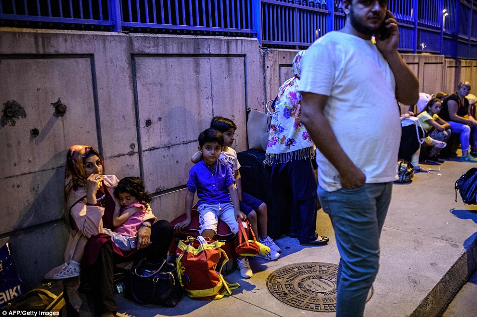 35C413E000000578-3664710-Families_wait_outside_the_terminal_with_their_luggage_after_all_-a-27_1467156134842