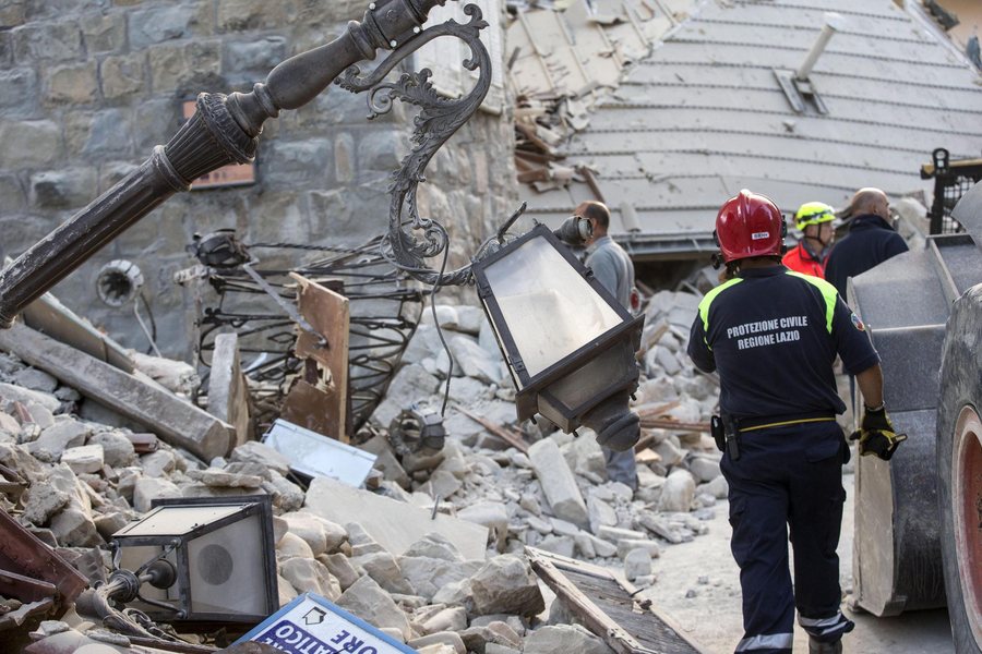 epa05508218 Members of the Protezione Civile (Civil Protection) department operate on the rubble of a collapsed building in Amatrice, central Italy, 24 August 2016, following a 6.2 magnitude earthquake, according to the United States Geological Survey (USGS), that struck at around 3:30 am local time (1:30 am GMT). The quake was felt across a broad section of central Italy, including the capital Rome where people in homes in the historic center felt a long swaying followed by aftershocks. According to reports at least 21 people died in the quake, 11 in Lazio and 10 in Marche regions.  EPA/MASSIMO PERCOSSI