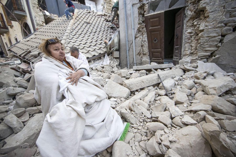 epa05508219 Residents are seen in front of collapsed houses in Amatrice, central Italy, 24 August 2016, following a 6.2 magnitude earthquake, according to the United States Geological Survey (USGS), that struck at around 3:30 am local time (1:30 am GMT). The quake was felt across a broad section of central Italy, including the capital Rome where people in homes in the historic center felt a long swaying followed by aftershocks. According to reports at least 21 people died in the quake, 11 in Lazio and 10 in Marche regions.  EPA/MASSIMO PERCOSSI