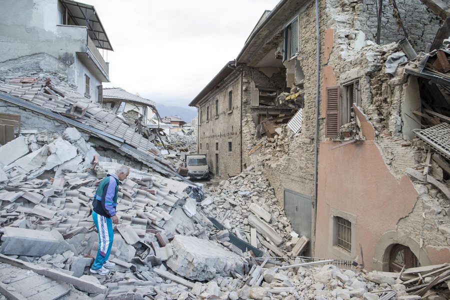 epa05508228 A man walks on the rubble of collapsed buildings in Amatrice, central Italy, 24 August 2016, following a 6.2 magnitude earthquake, according to the United States Geological Survey (USGS), that struck at around 3:30 am local time (1:30 am GMT). The quake was felt across a broad section of central Italy, including the capital Rome where people in homes in the historic center felt a long swaying followed by aftershocks. According to reports at least 21 people died in the quake, 11 in Lazio and 10 in Marche regions.  EPA/MASSIMO PERCOSSI