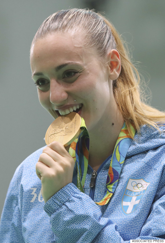 Anna Korakaki of Greece bites her gold medal after the award ceremony for the women's 25 meter pistol competition at Olympic Shooting Center at the 2016 Summer Olympics in Rio de Janeiro, Brazil, Tuesday, Aug. 9, 2016. (AP Photo/Eugene Hoshiko)