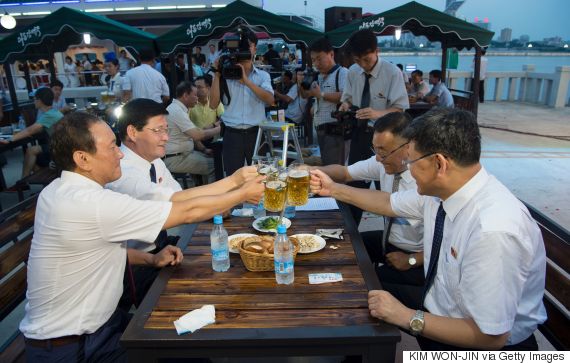 This photo taken on August 12, 2016 shows Choe Yong Nam (L), director of the General Bureau of Public Service who doubles as chairman of the preparatory committee for the festival, saying "cheers" with other officials after the opening ceremony of the Pyongyang Taedonggang Beer Festival on the banks of the Taedong river in Pyongyang. / AFP / Kim Won-Jin        (Photo credit should read KIM WON-JIN/AFP/Getty Images)