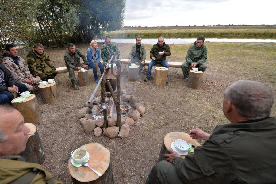epa05533966 Russian President Vladimir Putin (2-R) and Prime Minister Dmitry Medvedev (C) sit with fishermen for dinner during an election campaign visit on Lake Ilmen, Novgorod region, Russia, 10 September 2016. President Putin and Prime Minister Medvedev, chairman of United Russia party, are campaigning for United Russia party for the Stgate Duma  legislative elections to be held on 18 September 2016.  EPA/ALEXEI DRUZHININ / SPUTNIK/ KREMLIN POOL MANDATORY CREDIT