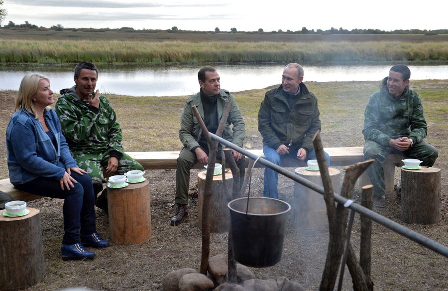 epa05533967 Russian President Vladimir Putin (2-R) and Prime Minister Dmitry Medvedev (C) sit with fishermen for dinner during an election campaign visit on Lake Ilmen, Novgorod region, Russia, 10 September 2016. President Putin and Prime Minister Medvedev, chairman of United Russia party, are campaigning for United Russia party for the Stgate Duma  legislative elections to be held on 18 September 2016.  EPA/ALEXEI DRUZHININ / SPUTNIK/ KREMLIN POOL MANDATORY CREDIT