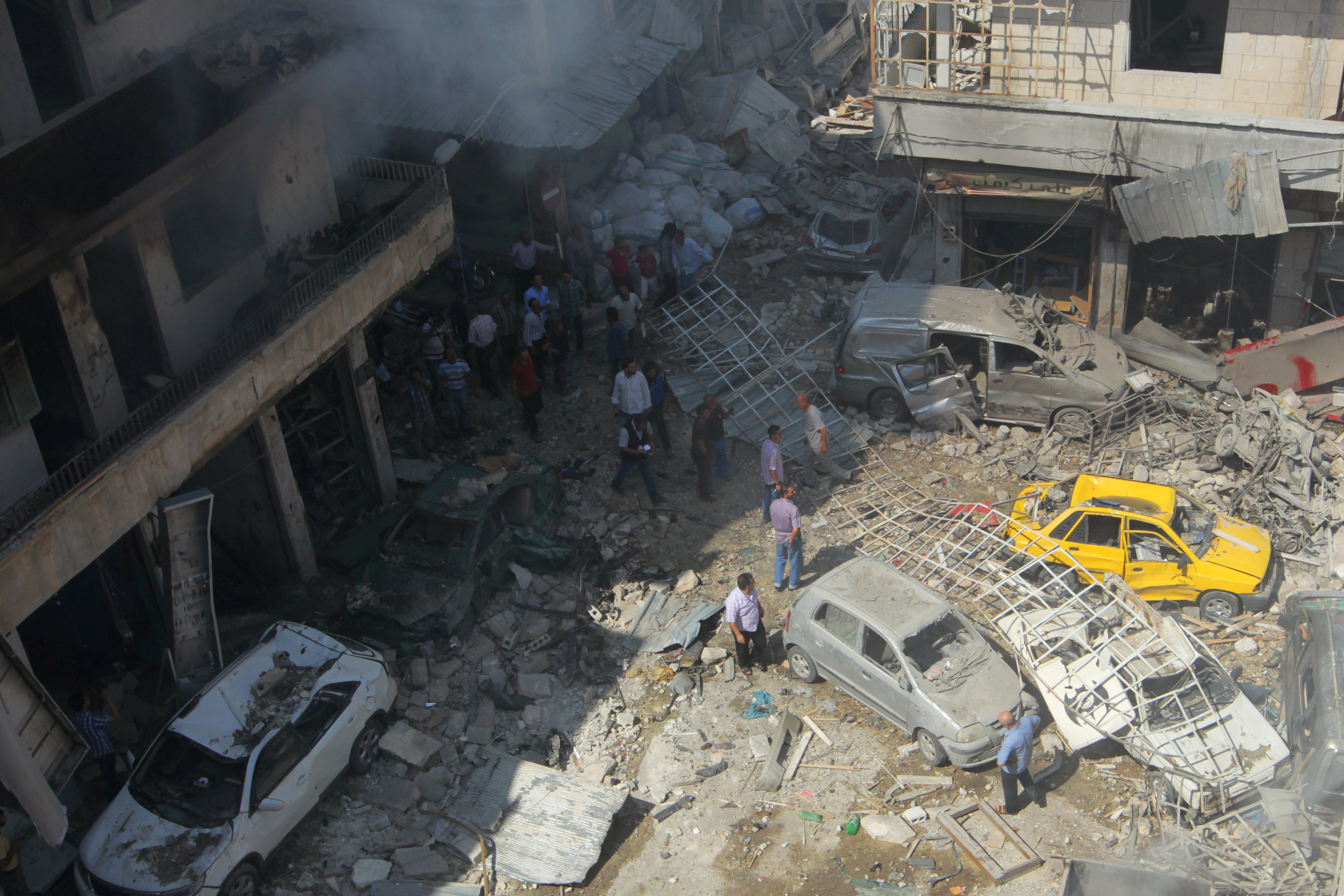 Residents inspect a damaged site after airstrikes on a market in the rebel controlled city of Idlib September 10, 2016. REUTERS/Ammar Abdullah