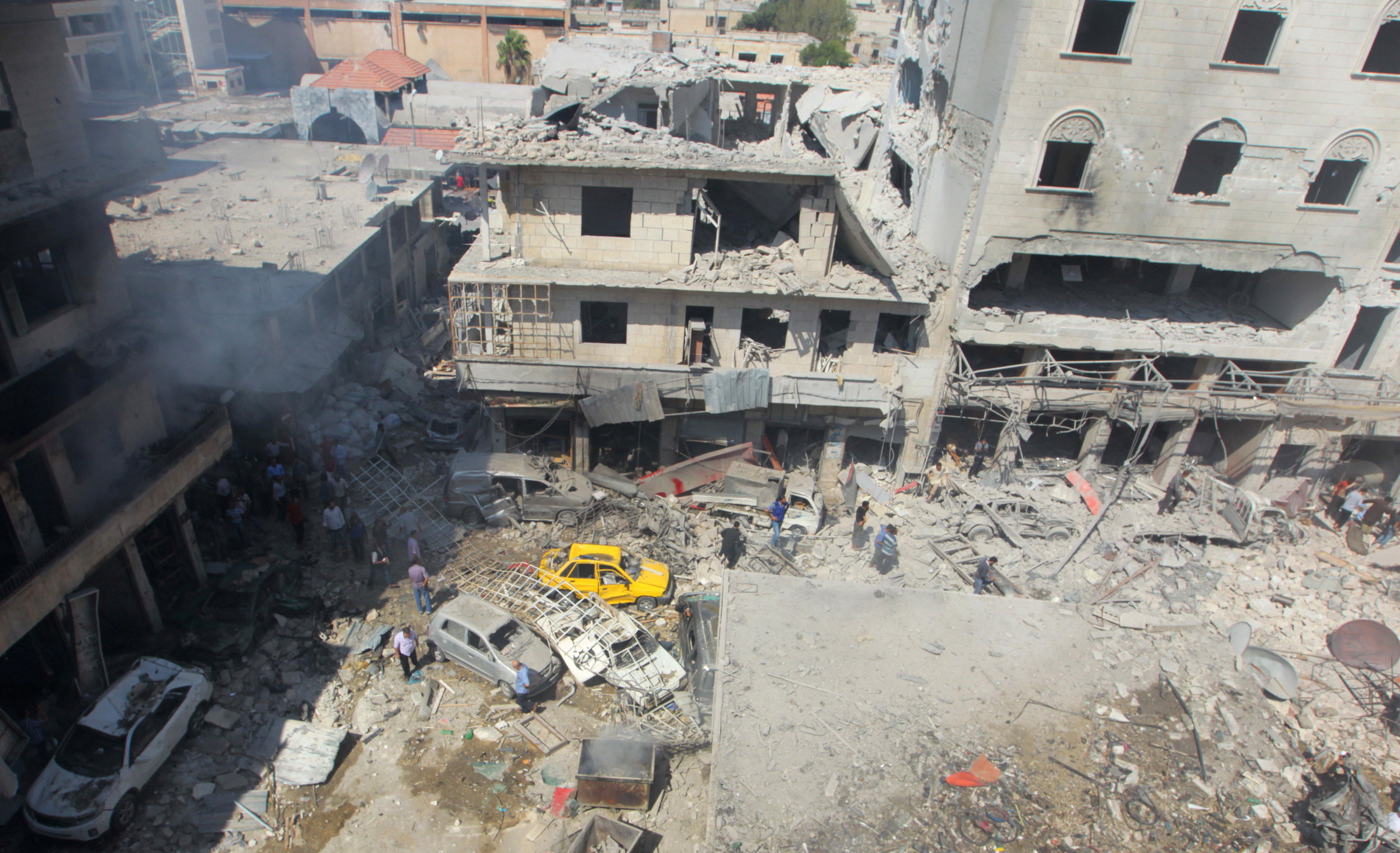 Residents inspect a damaged site after airstrikes on a market in the rebel controlled city of Idlib September 10, 2016. REUTERS/Ammar Abdullah
