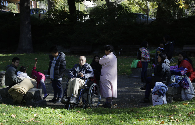 People sit outside in a town park in Norcia, central Italy, after an earthquake with a preliminary magnitude of 6.6 struck central Italy, Sunday, Oct. 30, 2016. A powerful earthquake rocked the same area of central and southern Italy hit by quake in August and a pair of aftershocks last week, sending already quake-damaged buildings crumbling after a week of temblors that have left thousands homeless. (AP Photo/Gregorio Borgia)