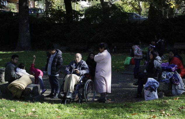 People sit outside in a town park in Norcia, central Italy, after an earthquake with a preliminary magnitude of 6.6 struck central Italy, Sunday, Oct. 30, 2016. A powerful earthquake rocked the same area of central and southern Italy hit by quake in August and a pair of aftershocks last week, sending already quake-damaged buildings crumbling after a week of temblors that have left thousands homeless.  (AP Photo/Gregorio Borgia)