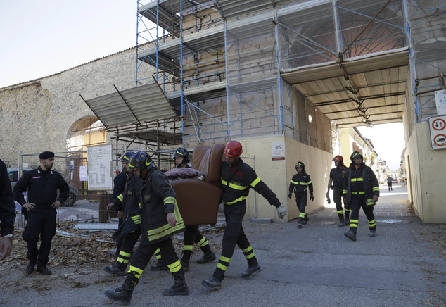Italian firefighters carry an armchair from the historical center of Norcia, central Italy, which has been sealed off, after an earthquake with a preliminary magnitude of 6.6 struck central Italy, Sunday, Oct. 30, 2016. A powerful earthquake rocked the same area of central and southern Italy hit by quake in August and a pair of aftershocks last week, sending already quake-damaged buildings crumbling after a week of temblors that have left thousands homeless.  (AP Photo/Gregorio Borgia)