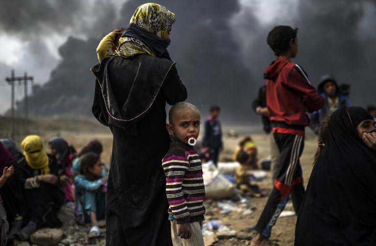Iraqi families who were displaced by the ongoing operation by Iraqi forces against jihadists of the Islamic State group to retake the city of Mosul, are seen gathering in an area near Qayyarah on October 24, 2016.  The UN refugee agency is preparing to receive 150,000 Iraqis fleeing fighting around the Islamic State group-held city of Mosul within the next few days, its chief said.  / AFP PHOTO / BULENT KILIC