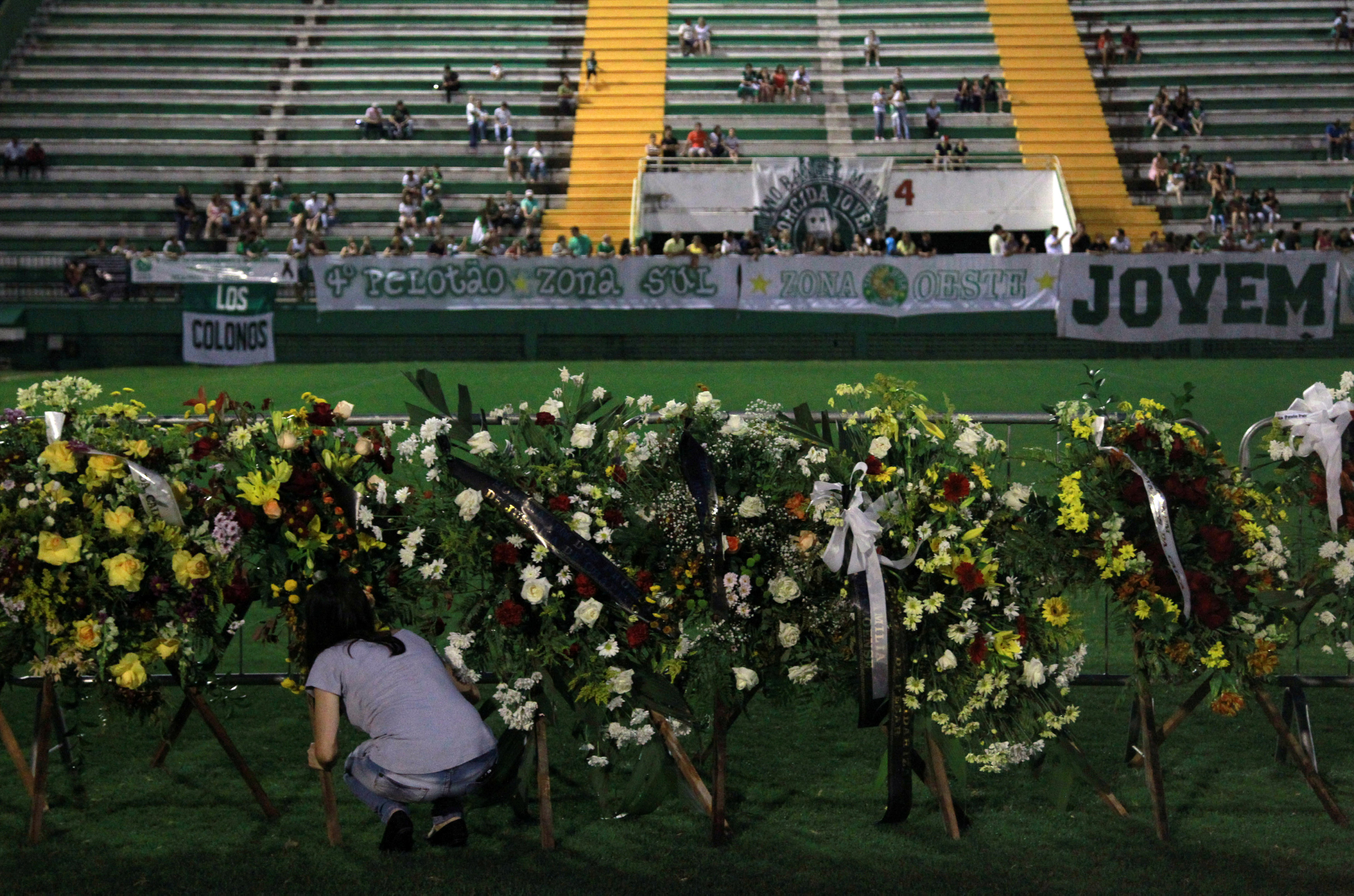 A woman places flowers before a mourning ceremony for victims after a plane carrying Brazil's soccer team Chapecoense crashed in Colombia, at Arena Conda stadium in Chapeco