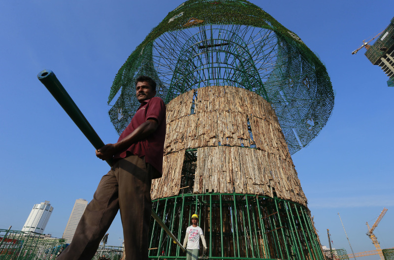 A Sri Lankan port workers carry steel rods to ensemble a Christmas tree making out of iron in Colombo, Sri Lanka, Thursday, Dec. 15, 2016. (AP Photo/Eranga Jayawardena)