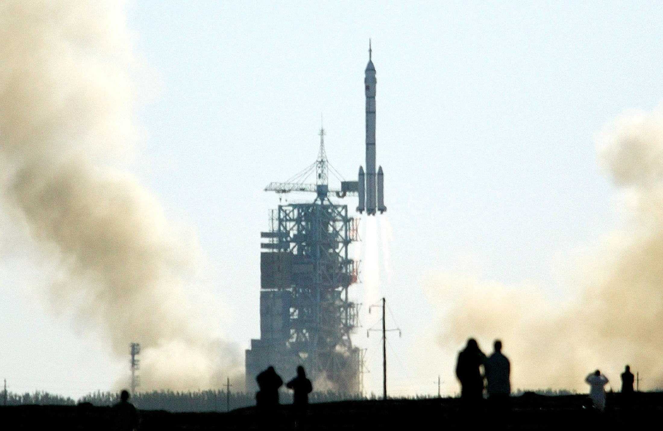 CHINESE WATCH THE LAUNCH OF CHINA'S FIRST MANNED SPACE FLIGHT AT THEJIUQUAN SATELLITE LAUNCH CENTRE.