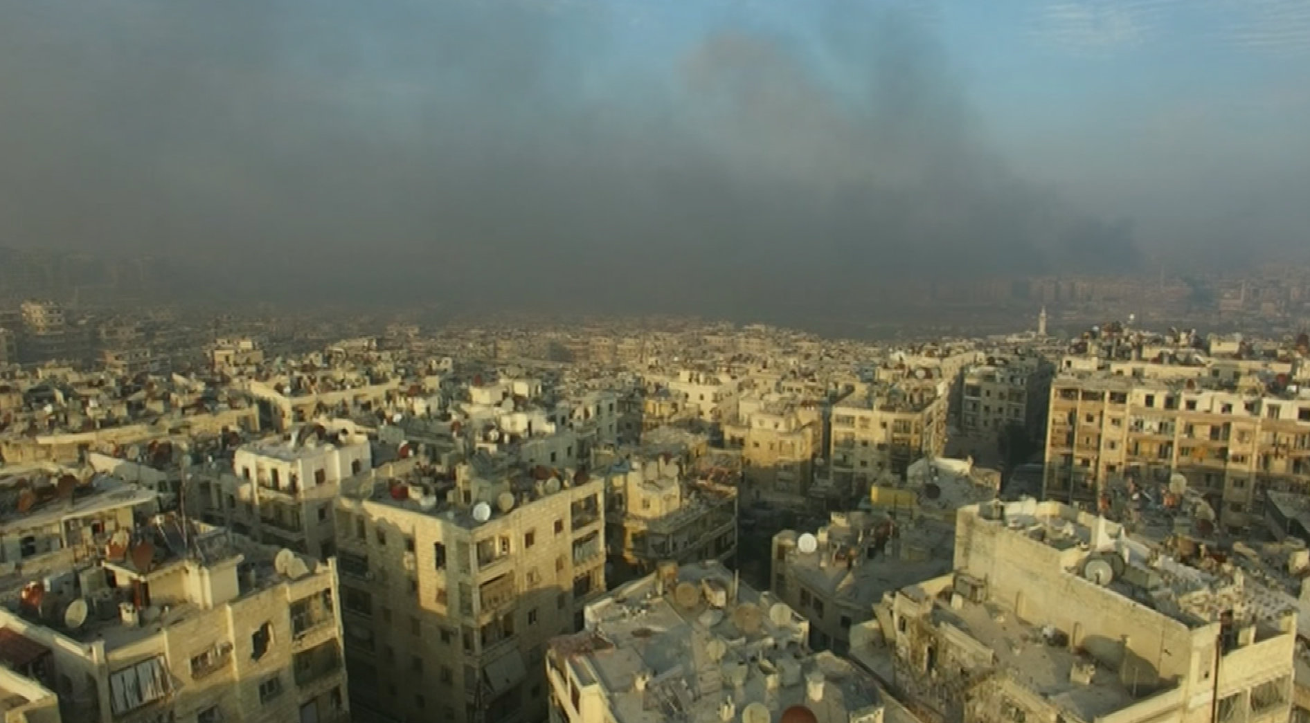 A still image from video taken December 12, 2016 of a general view of smoke rising over bomb damaged eastern Aleppo, Syria. Video released December 12, 2016.      REUTERS/via ReutersTV