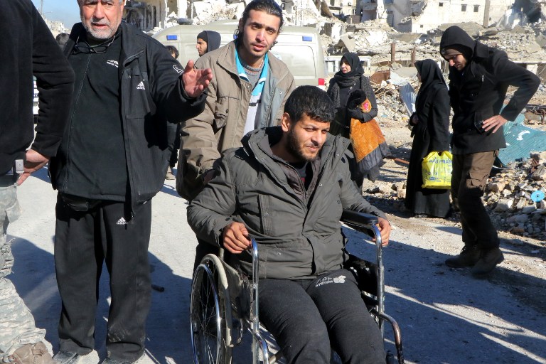 ALEPPO, SYRIA - DECEMBER 15: A wounded civilian is being brought near a convoy, including busses and ambulances those wait at a crossing point at Amiriyah District of Aleppo Syria on December 15, 2016 to evacuate civilians, trying to flee from East Aleppo where had been under siege by Iran led Shiite militias and Assad Regime forces. Ibrahim Ebu Leys / Anadolu Agency