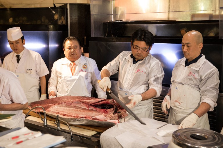 Employees of sushi restaurant chain Sushi-Zanmai prepare a 212-kilogram bluefin tuna at their restaurant near the Tsukiji fish market in Tokyo on January 5, 2017. Japan's self-styled "Tuna King" has done it again -- paying more than 600,000 USD for a single fish. Sushi entrepreneur Kiyoshi Kimura paid top price at the first auction of the new year at Tokyo's Tsukiji fish market on January 5, bagging a prized bluefin tuna for an eye-watering 74.2 million yen (636,000 USD).  / AFP PHOTO / Behrouz MEHRI
