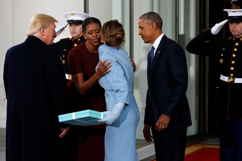 U.S. President-elect Donald Trump (L) and his wife Melania (3rd L) present a gift to U.S. first lady Michelle Obama and President Barack Obama as the Trumps arrive for tea before the inauguration at the White House in Washington, U.S. January 20, 2017. REUTERS/Jonathan Ernst