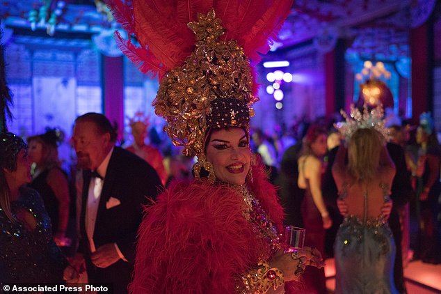 A guest in a costume poses for the photo as she enjoys a traditional Carnival ball at the Copacabana Palace hotel in Rio de Janeiro, Brazil, Saturday, Feb. 25, 2017. In stark contrast to the hundreds of hard-charging street parties across Rio that are open to anyone, the "Baile do Copa" bills itself as a fairytale event where the country's elite can see and be seen in a hotel known for both opulence and a lengthy tradition of welcoming world leaders and stars. (AP Photo/Leo Correa)