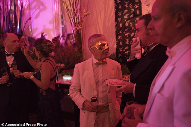 A masked guest attends a traditional Carnival ball at the Copacabana Palace hotel in Rio de Janeiro, Brazil, Saturday, Feb. 25, 2017. In stark contrast to the hundreds of hard-charging street parties across Rio that are open to anyone, the "Baile do Copa" bills itself as a fairytale event where the country's elite can see and be seen in a hotel known for both opulence and a lengthy tradition of welcoming world leaders and stars. (AP Photo/Leo Correa)