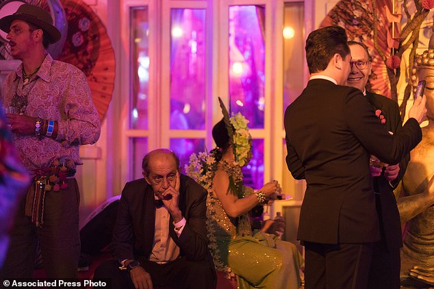 A guest, second left, reacts as he attends a traditional Carnival ball at the Copacabana Palace hotel in Rio de Janeiro, Brazil, Saturday, Feb. 25, 2017. In stark contrast to the hundreds of hard-charging street parties across Rio that are open to anyone, the "Baile do Copa" bills itself as a fairytale event where the country's elite can see and be seen in a hotel known for both opulence and a lengthy tradition of welcoming world leaders and stars. (AP Photo/Leo Correa)