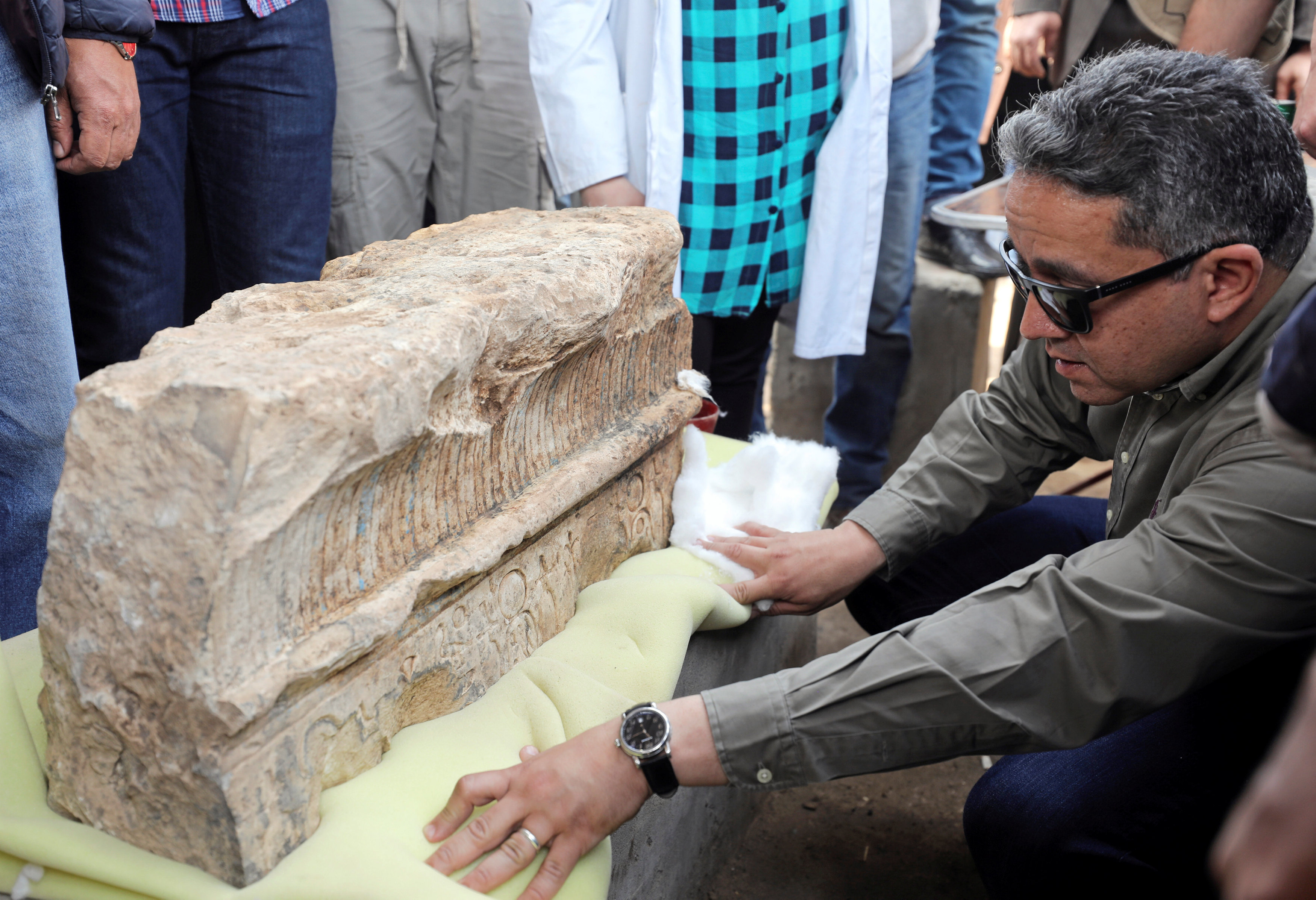 Antiquities Minister Khaled al-Anani inspects an unearthed statue that workers say depicts revered Pharaoh Ramses II who ruled Egypt over 3,000 years ago, at the Matariya area in Cairo