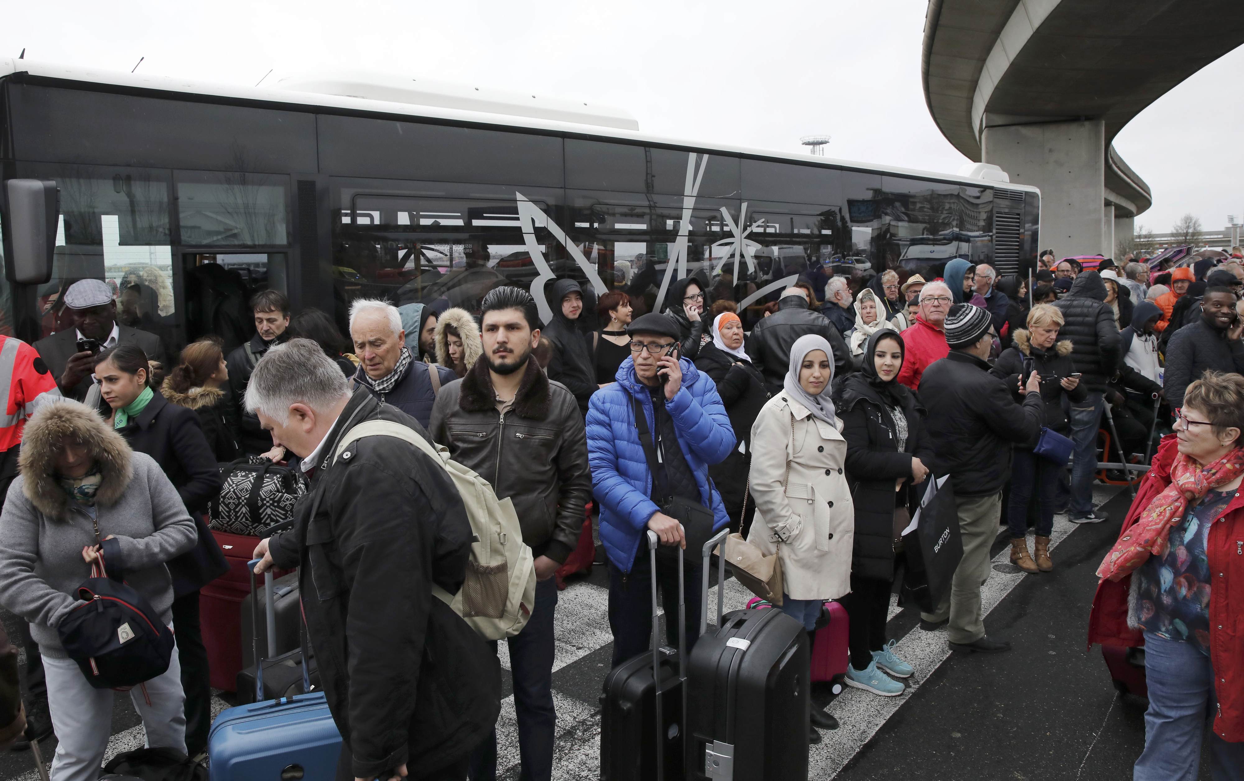 Passengers wait at Orly airport southern terminal after shooting incident near Paris