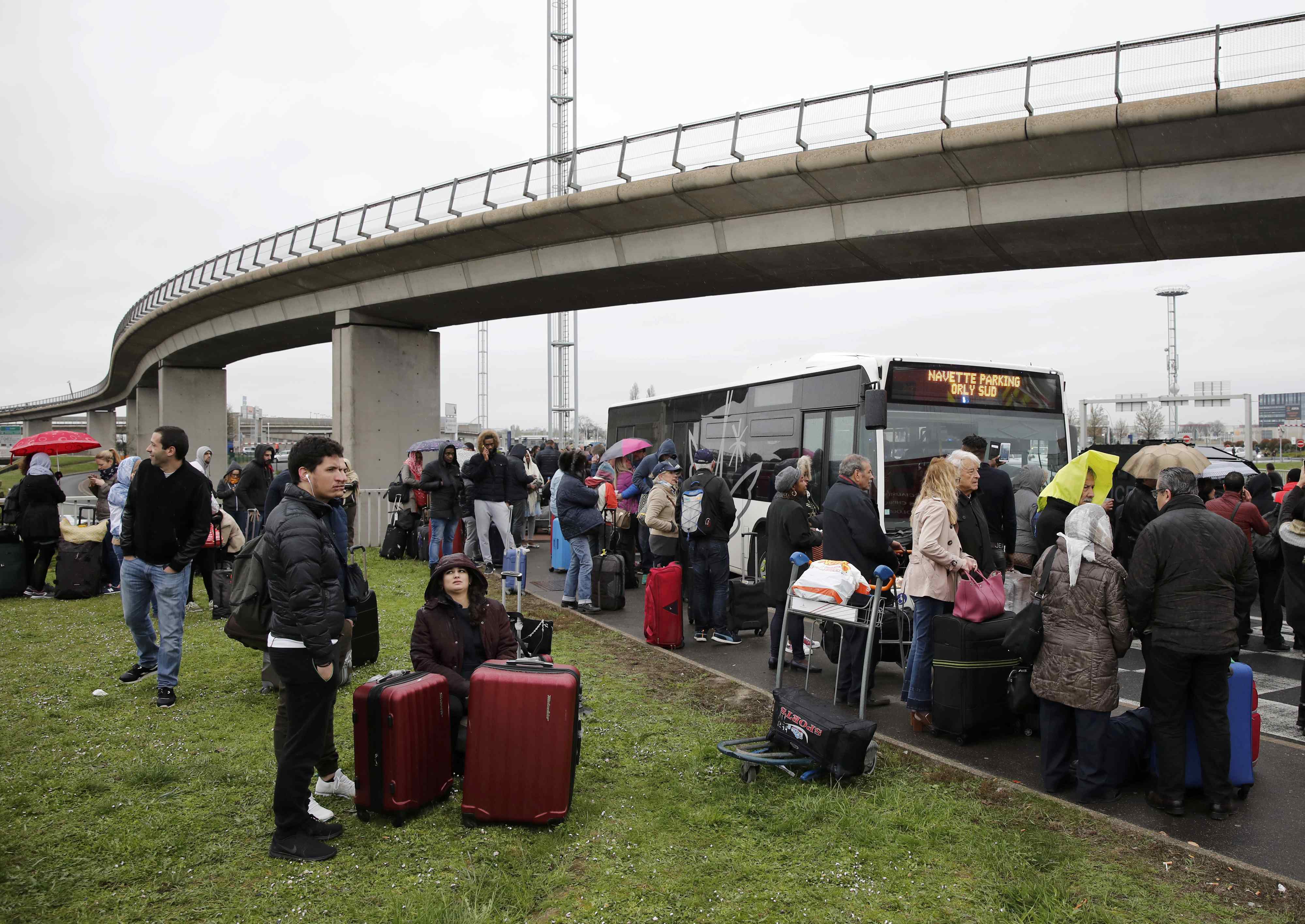 Passengers wait at Orly airport southern terminal after shooting incident near Paris