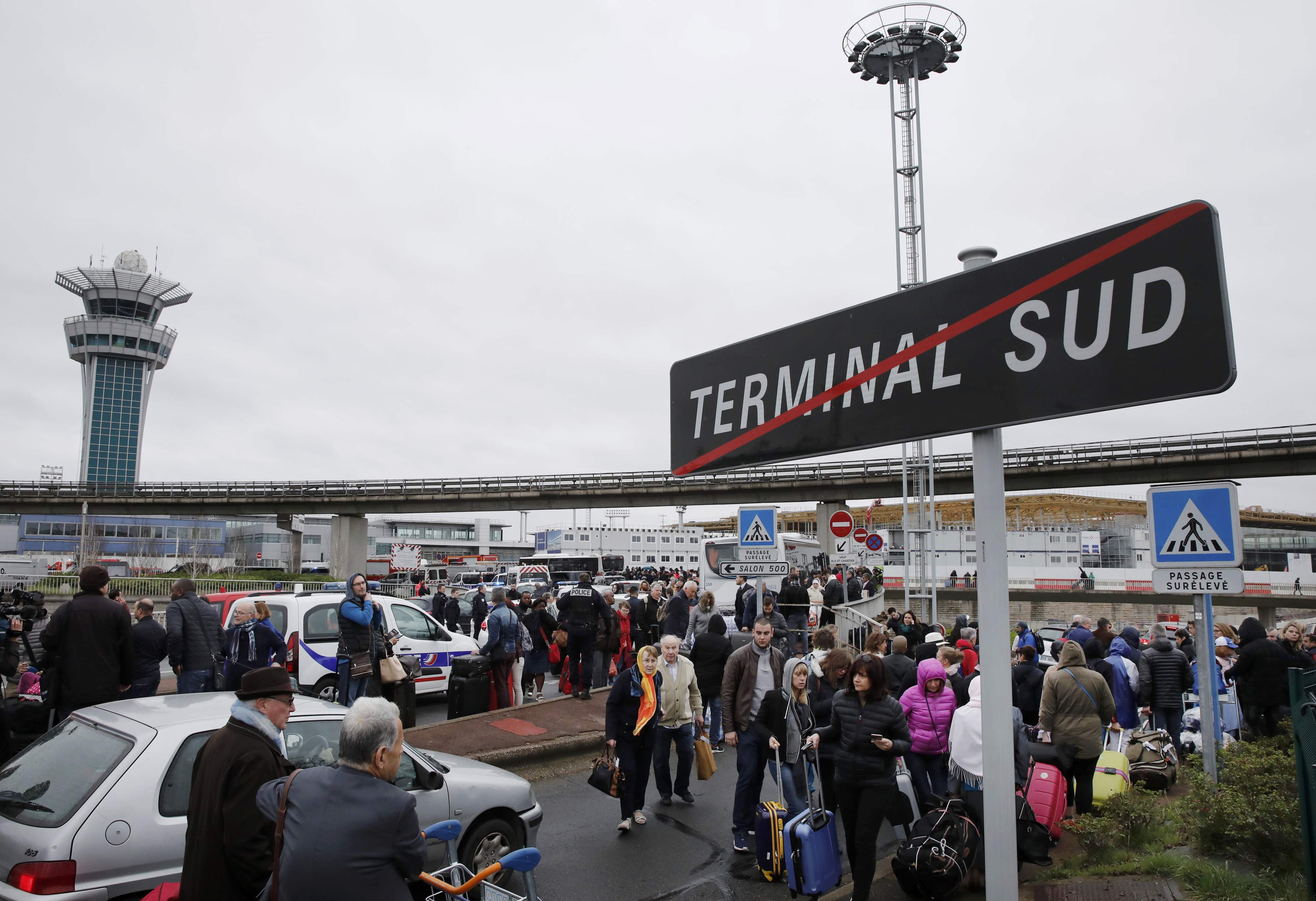 Passengers wait at Orly airport southern terminal after shooting incident near Paris