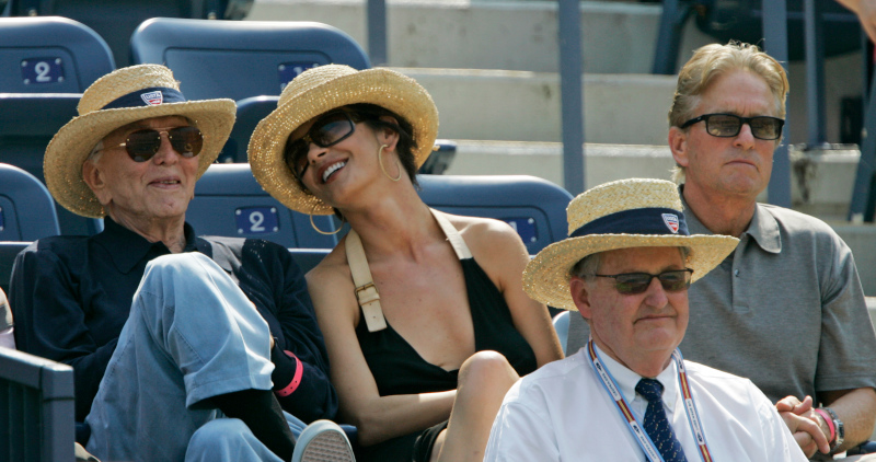 Catherine Zeta-Jones sits between Kirk Douglas, left, and her husband, Michael Douglas, during the semifinal match betweeen Novak Djokovic of Serbia and David Ferrer of Spain at the US Open tennis tournament in New York, Saturday, Sept. 8, 2007. (AP Photo/Elise Amendola)