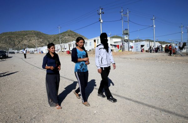 A Yazidi boy, 16, who was trained by Islamic State, wraps his head in a scarf as he walks with other refugees at a refugee camp near the northern Iraqi city of Duhok April 19, 2016. The stories of boys from the minority Yazidi community now living in a refugee camp near the northern Iraqi city of Duhok appear to show efforts by Islamic State to create a new generation of fighters loyal to the group's ideology and inured to its extreme violence. The training often leaves them scarred, even after returning home. REUTERS/Ahmed Jadallah SEARCH "YAZIDI CHILDREN" FOR THIS STORY. SEARCH "THE WIDER IMAGE" FOR ALL STORIES