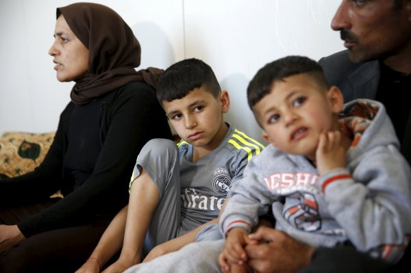 Freed Yazidi boy Murad (C), 9, who was trained by Islamic State, sits next to his five-year-old brother Emad and his parents at their home in a refugee camp near the northern Iraqi city of Duhok April 19, 2016. The stories of boys from the minority Yazidi community now living in a refugee camp near the northern Iraqi city of Duhok appear to show efforts by Islamic State to create a new generation of fighters loyal to the group's ideology and inured to its extreme violence. The training often leaves them scarred, even after returning home. REUTERS/Ahmed Jadallah SEARCH "YAZIDI CHILDREN" FOR THIS STORY. SEARCH "THE WIDER IMAGE" FOR ALL STORIES