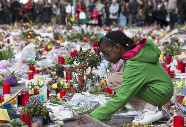 A girl lays a flower on a street memorial during a rally called "The march against the fear, Tous Ensemble, Samen Een, All Together" in memory for the victims of bomb attacks in Brussels metro and Brussels international airport of Zaventem, in Brussels, Belgium, April 17, 2016. REUTERS/Yves Herman