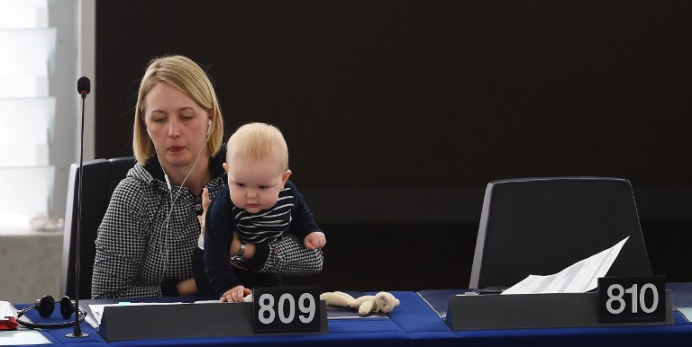 Member of the European Parliament Swedish Jytte Guteland holds her baby as she takes part in a voting session at the European Parliament in Strasbourg, eastern France, on March 14, 2017.  / AFP PHOTO / FREDERICK FLORIN