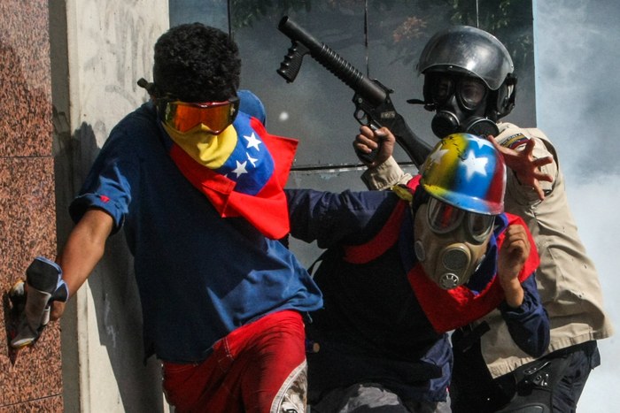 epa05977863 Protesters clash with members of the Bolivarian National Police (PNB) during an anti-government march in Caracas, Venezuela, 20 May 2017. Venezuelan security forces used tear gas to disperse demonstrators who were trying to reach the headquarters of the Interior Ministry, in the city center. Anti-government demonstrators have led protests against Venezuelan President Nicolas Maduro for 50 days paralyzing the divided country. At least 47 people died in violence related to the protests, media reported.  EPA/CRISTIAN HERNANDEZ