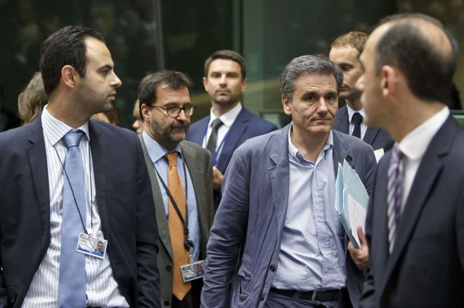 Greek Finance Minister Euclid Tsakalotos, third right, arrives for a round table meeting of eurozone finance ministers at the EU LEX building in Brussels on Tuesday, July 7, 2015. Greek Prime Minister Alexis Tsipras was heading Tuesday to Brussels for an emergency meeting of eurozone leaders, where he will try to use a resounding referendum victory to eke out concessions from European creditors over a bailout for the crisis-ridden country. (AP Photo/Michel Euler)
