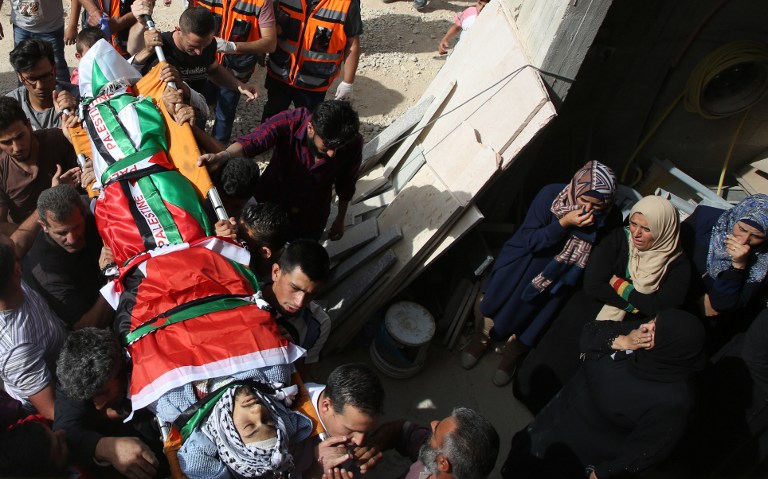 Mourners carry the body of 23-year-old Palestinian Muataz Bani Shemsay, who according to Palestinian security forces was killed by an Israeli settler during clashes near Nablus, during his funeral procession in the West Bank village of Beita on May 18, 2017. 
The clash near a military post erupted when an Israeli settler in a car attempted to cross a crowd of Palestinian protesters, with the settler and Israeli soldiers opening fire, Palestinian security sources said. / AFP PHOTO / JAAFAR ASHTIYEH