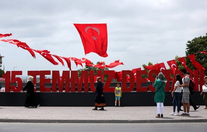 epa06087048 People walks in front of a huge fonts that reads '15 July Epic' in Istanbul, Turkey, 14 July 2017. The 15 July 2017 event marks the first anniversary of the failed coup attempt which led to some 50 thousand workers being dismissed, some eight thousand people arrested, and scores of news outlets shut down by the government. Turkish President Recep Tayyip Erdogan blamed US-based Turkish cleric Fetullah Gulen and his movement for masterminding the failed coup and Turkey remains under a state of emergency as a result.  EPA/ERDEM SAHIN