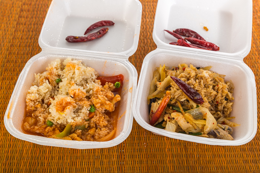 Two styrofoam boxes of leftovers meals from Thai Restaurant. Sweet and Sour Chicken and Phad Thai -- Thai Stir Fry.