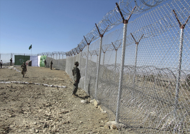 Pakistani soldiers stand guard at newly erected fence between Pakistan and Afghanistan at Angore Adda, Pakistan Wednesday, Oct. 18, 2017. Pakistan's military says new fencing and guard posts will help prevent militant attacks. (AP Photo/Mohammad Yousaf)