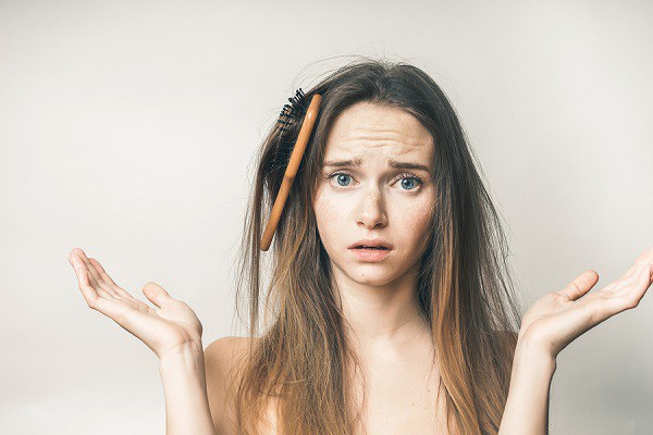 Hair comb in hairs,problems,questioning woman,looks sad, on a white background