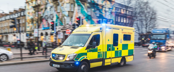 Emergency ambulance rushing on the street with emergency lights flashing in London city centre
