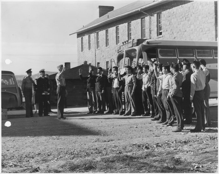 First_29_Navajo_U.S._Marine_Corps_code-talker_recruits_being_sworn_in_at_Fort_Wingate_NM._-_NARA_-_295175-696x553