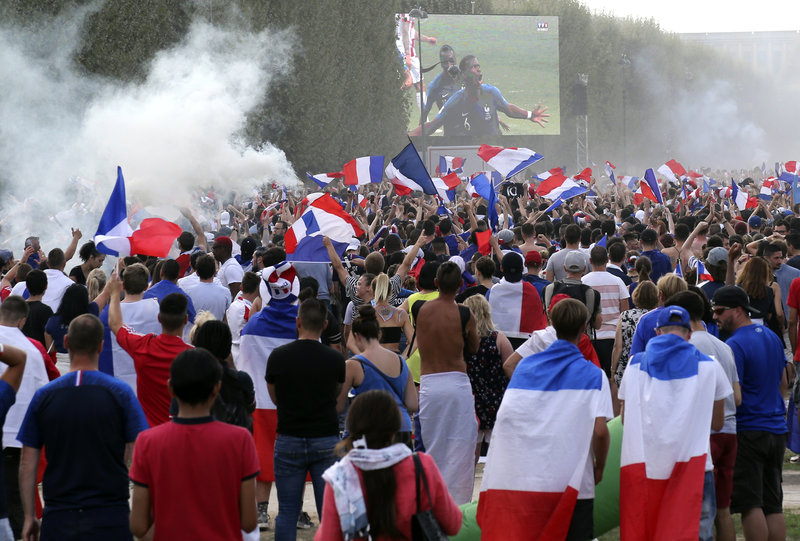 Supporters of the French soccer team react after France's third goal as they watch the World Cup final between France and Croatia, Sunday, July 15, 2018 on the Champ de Mars in Paris. (AP Photo/Bob Edme)