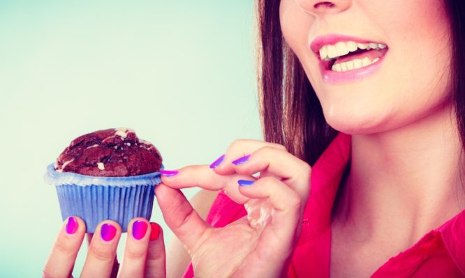 smiling-woman-holds-chocolate-cake-in-hand-picture-id488088264-666x399