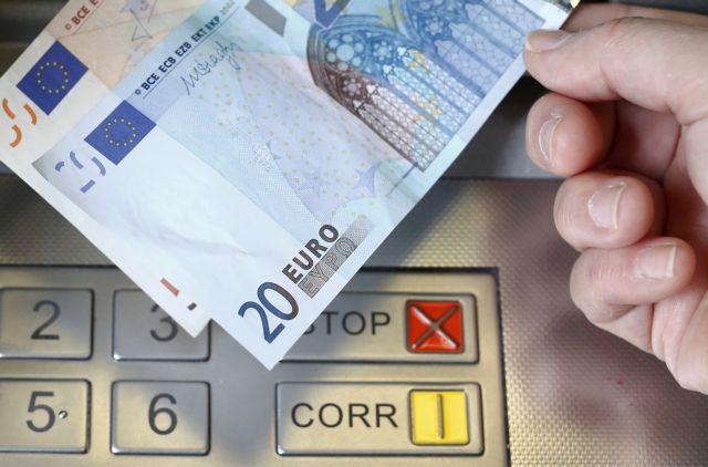 A woman holds a 20 and 50 Euro bank notes in front of an ATM in this illustration picture taken in Bern January 16, 2015. German bond yields hit record lows on Friday while fears about Greek banks sent the country's borrowing costs spiralling - signs of the fallout from the Swiss National Bank's shock decision to scrap its currency cap. A surge in the Swiss franc after the SNB abandoned its 1.20 euro limit on Thursday saw investors flee equities and other risky assets, parking money instead in top-rated bonds.  REUTERS/Thomas Hodel (SWITZERLAND  - Tags: BUSINESS POLITICS)