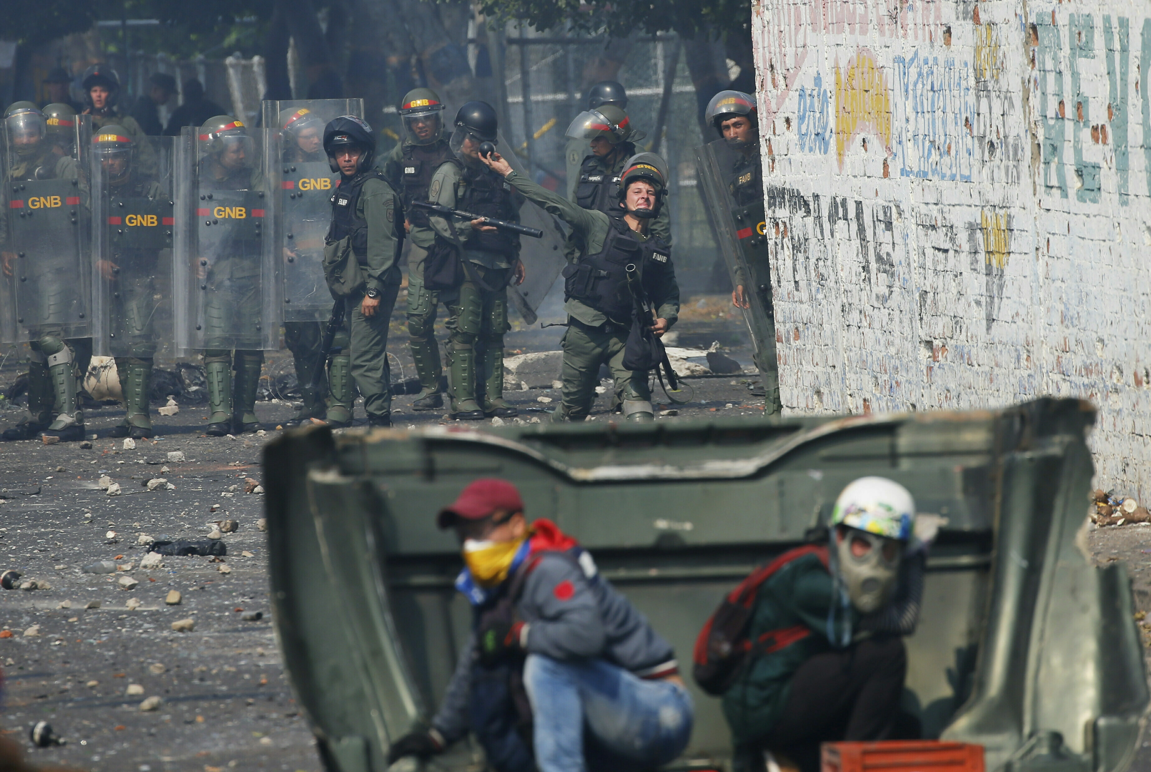 A Venezuelan Bolivarian National Guard officer throws a teargas grenade towards demonstrator during clashes in Urena, Venezuela, near the bordr with Colombia, Saturday, Feb. 23, 2019. Venezuela's National Guard fired tear gas on residents clearing a barricaded border bridge between Venezuela and Colombia on Saturday, heightening tensions over blocked humanitarian aid that opposition leader Juan Guaido has vowed to bring into the country over objections from President Nicolas Maduro.(AP Photo/Fernando Llano)