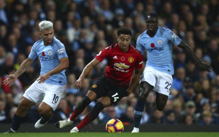 Manchester City's Sergio Aguero, left, Manchester United's Jesse Lingard, centre, and Manchester City's Benjamin Mendy challenge for the ball during the English Premier League soccer match between Manchester City and Manchester United at the Etihad stadium in Manchester, England, Sunday, Nov. 11, 2018. (AP Photo/Dave Thompson)