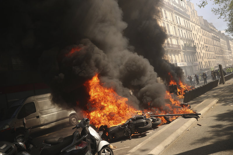 A set of motorbikes are set alight during a yellow vest demonstration in Paris, Saturday, April 20, 2019. French yellow vest protesters are marching anew to remind the government that rebuilding the fire-ravaged Notre Dame Cathedral isn't the only problem the nation needs to solve. (AP Photo/Francisco Seco)