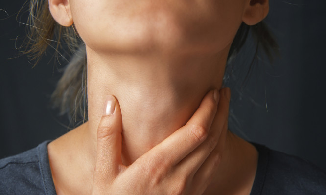 Woman holds her throat, sore throat