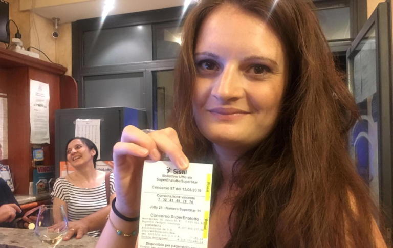epa07772119 The owner of the Marino's bar, Sara Poggi, shows the receipt of the winning ticket in the 'SuperEnalotto lottery which was purchased at the bar in Lodi, Italy, 13 August 2019. The value of the winning ticket is 209 million euro.  EPA/LAURA GOZZINI